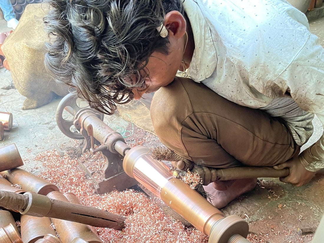 Kaarigar artisan shaping a seamless pure copper bottle by hand on a spinning machine